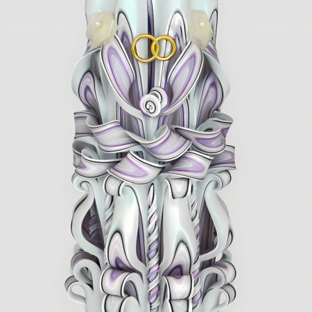 Handgefertigte, kunstvoll geschnitzte Hochzeitskerze in Weiß und zarten Lavendeltönen, dekoriert mit goldenen Eheringen und kleinen Kunstblumen.