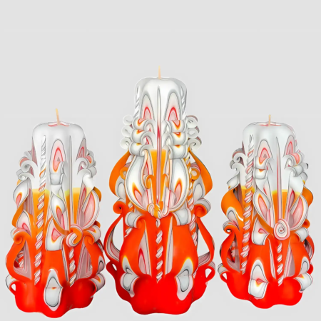 Handgefertigte, kunstvoll geschnitzte Kerzen in Orange, Weiß und Gelb auf weißem Hintergrund.
