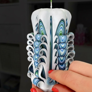 Bunt gefärbte Kerze mit vielen Windungen, Aussenschicht ist weiß, innen grün-blau-gestreift. Handgeschnitzt