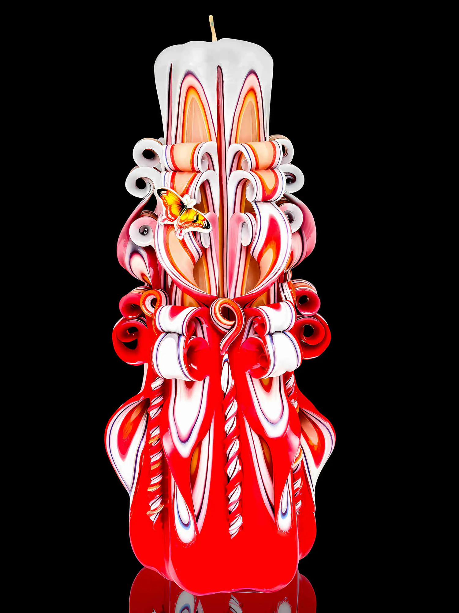 Kegelförmige sechseckige Kerze mit Schmetterling, handgeschnitzt, Farbe rot-weiß, Unikat aus der Devela Kerzenmanufaktur Berlin.