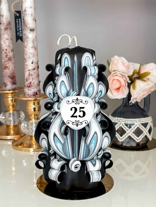 Individuell gestaltete Jubiläumskerze in Schwarz-Blau mit Schildchen „25“,