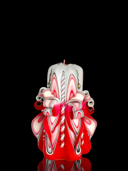 handgeschnitzte Kerze in rot-weiß mit kunstvollen Windungen