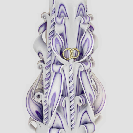 Handgeschnitzte weiße Hochzeitskerze mit zarten Lila-Akzenten und spiralförmigen floralen Schnitzmustern vor hellem Hintergrund.