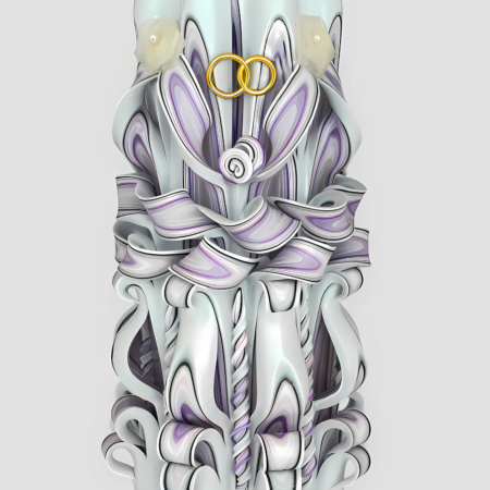 Handgeschnitzte weiße Hochzeitskerze mit feinen Flieder- und Silbertönen, goldenen Eheringen und DiosRöschen vor hellem Hintergrund.