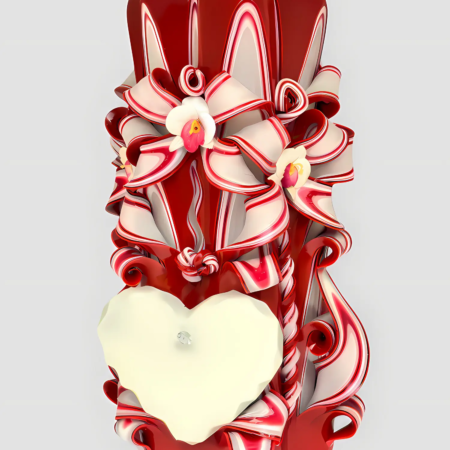 Handgeschnitzte rote Love-Kerze mit weißen Bändern aus Paraffin, Orchideen, einem leeren weißen Herzen und spiralförmigen Verzierungen vor hellem Hintergrund.