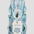 Handgeschnitzte Taufkerze in Babyblau mit Foto, Taufspruch und silbernem Kreuz – Vorderansicht. Oben ist ein Babyfoto, unten ein Schild mit Taufspruch