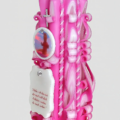 Seitenansicht der handgeschnitzten Taufkerze in zartem Rosa.