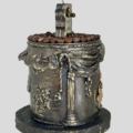 Handgefertigte Kaffeehaus Art-Kerze „Barista“ aus schwarzem Paraffin mit Kaffeebohnen, goldener Kaffeetasse und handmodellierten Vintage-Ornamenten.
