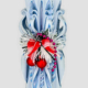 Handgeschnitzte Weihnachtskerze mit blauen Farbtönen, roter Weihnachtskette und roten Weihnachtskugel